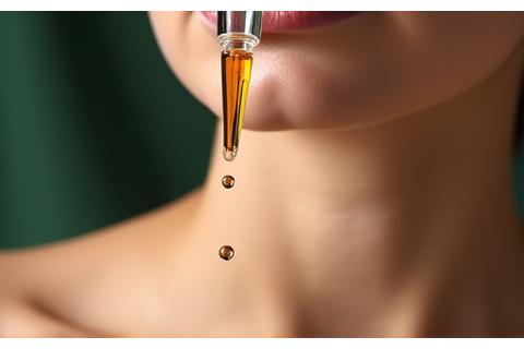 Close-up of advanced anti-aging serum being applied to a person's forehead with a dropper.