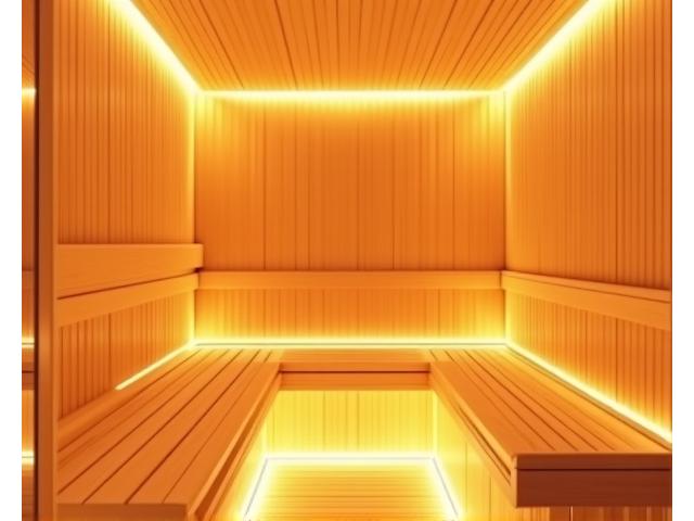 A modern sauna room with wooden benches and soft, warm lighting